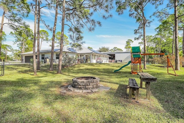 view of yard featuring a playground and an outdoor fire pit