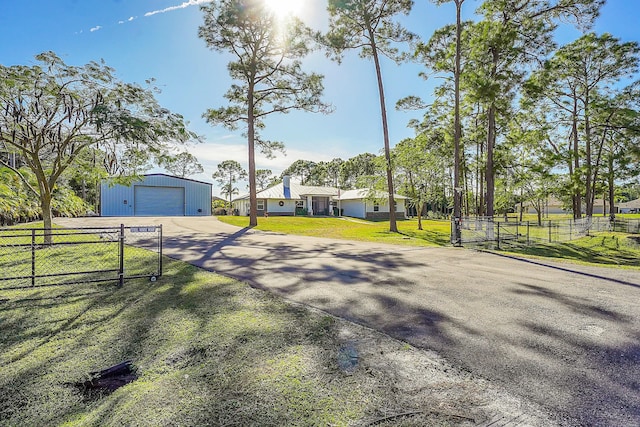 exterior space featuring a garage, a front lawn, and an outdoor structure