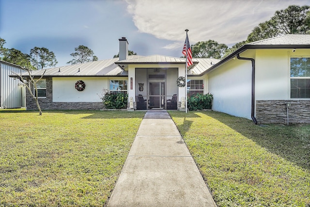 view of front of home with a front yard and a sunroom