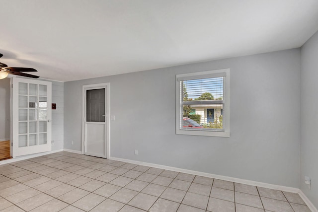 tiled spare room featuring ceiling fan