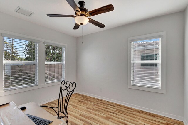 home office featuring ceiling fan, a healthy amount of sunlight, and light wood-type flooring