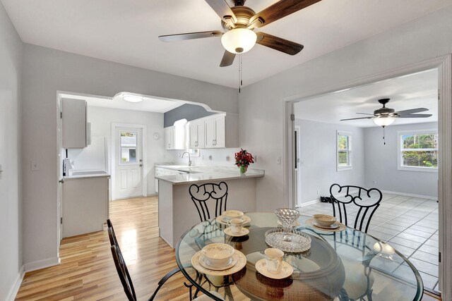 dining area featuring light hardwood / wood-style flooring, ceiling fan, a healthy amount of sunlight, and sink