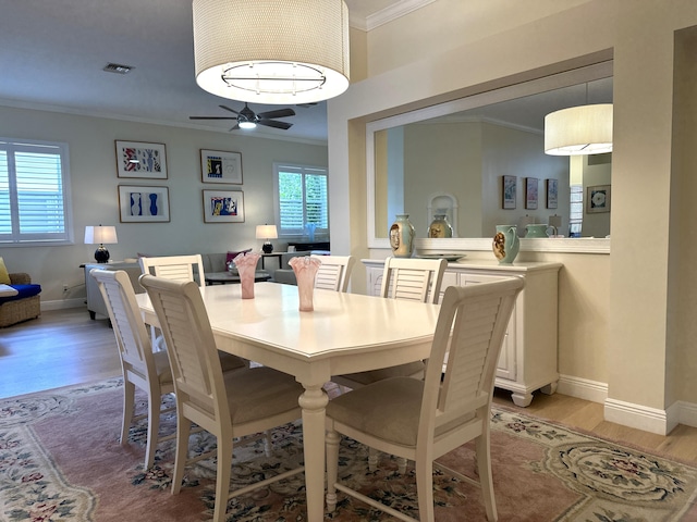 dining area with light wood-type flooring, ceiling fan, and ornamental molding