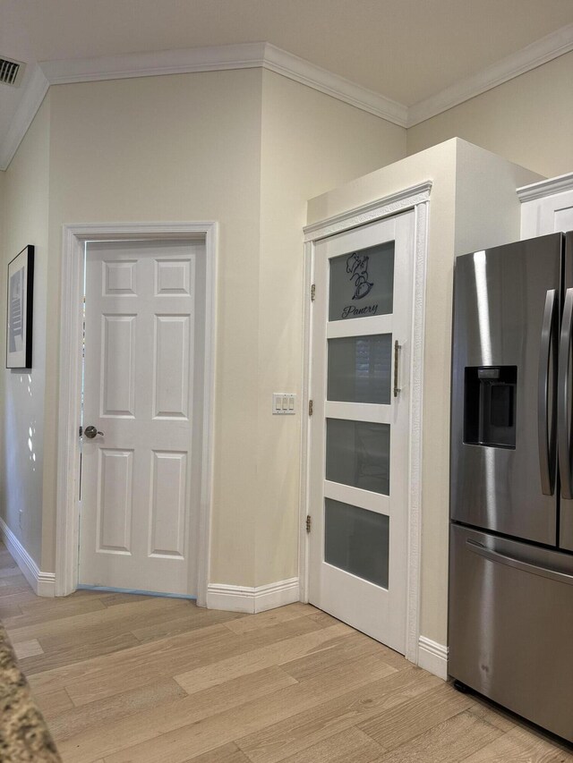 dining area with light wood-type flooring and ornamental molding