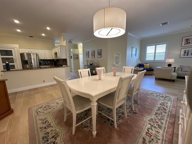 living room featuring light wood-type flooring, ceiling fan, and ornamental molding