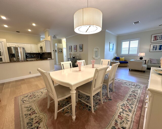 living room featuring light hardwood / wood-style floors, ceiling fan, and crown molding