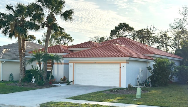 mediterranean / spanish house with a front yard and a garage