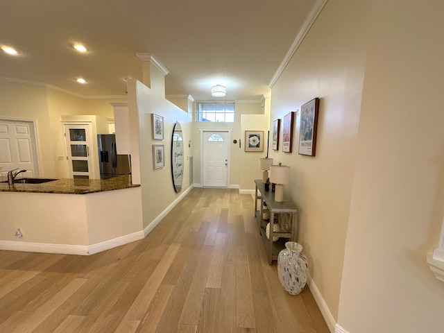 interior space featuring sink, light wood-type flooring, and ornamental molding