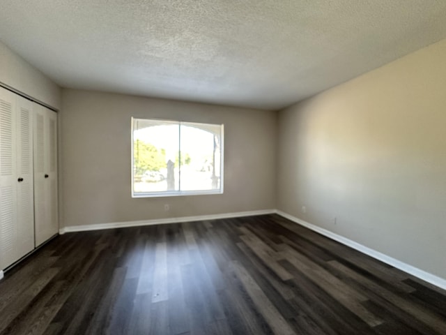 unfurnished bedroom featuring a closet, dark hardwood / wood-style flooring, and a textured ceiling