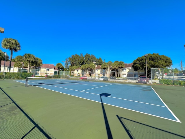 view of tennis court featuring basketball hoop