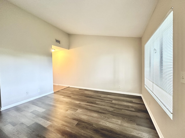 unfurnished room featuring dark hardwood / wood-style flooring and vaulted ceiling