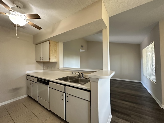 kitchen with hardwood / wood-style floors, white dishwasher, sink, white cabinetry, and kitchen peninsula