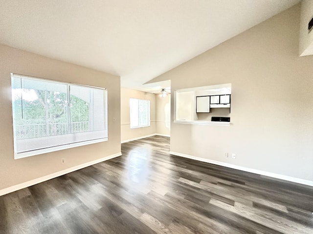 unfurnished living room featuring a wealth of natural light, dark hardwood / wood-style floors, and vaulted ceiling