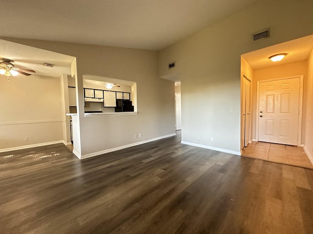 unfurnished living room with ceiling fan, lofted ceiling, and dark wood-type flooring