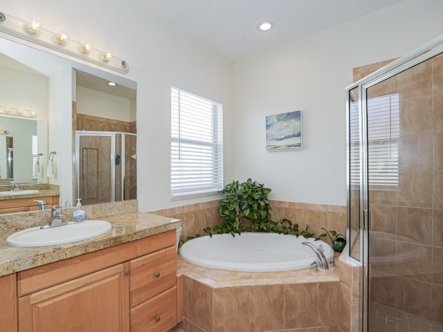 bathroom featuring vanity and independent shower and bath