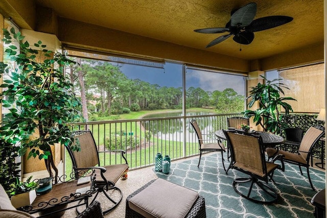 sunroom / solarium with a water view and ceiling fan