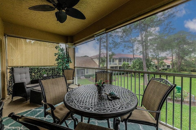 sunroom / solarium featuring a healthy amount of sunlight and ceiling fan