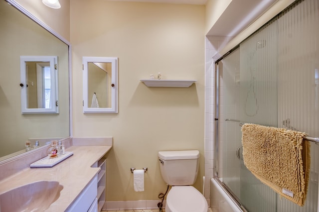 full bathroom featuring tile patterned flooring, vanity, toilet, and bath / shower combo with glass door