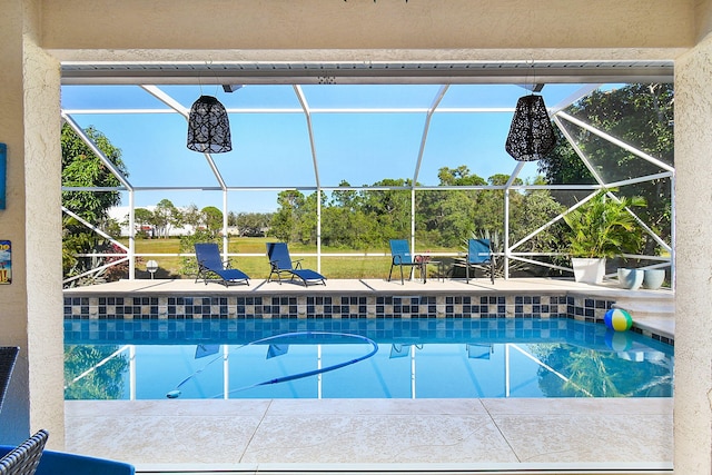 view of swimming pool featuring a patio and a lanai