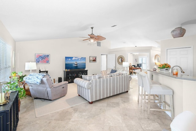 living room with ceiling fan, lofted ceiling, and sink