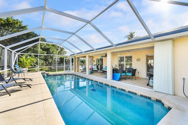 view of swimming pool featuring a patio area and glass enclosure