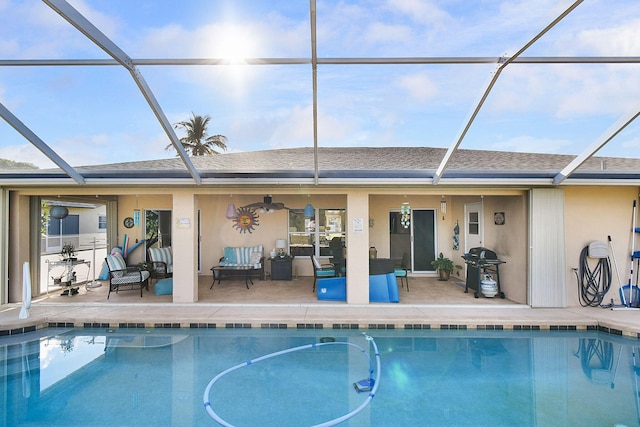 view of pool with glass enclosure and a patio area