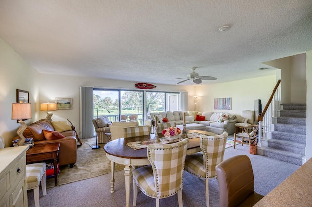 carpeted dining room with ceiling fan and a textured ceiling