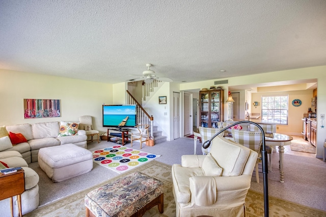 carpeted living room featuring a textured ceiling and ceiling fan