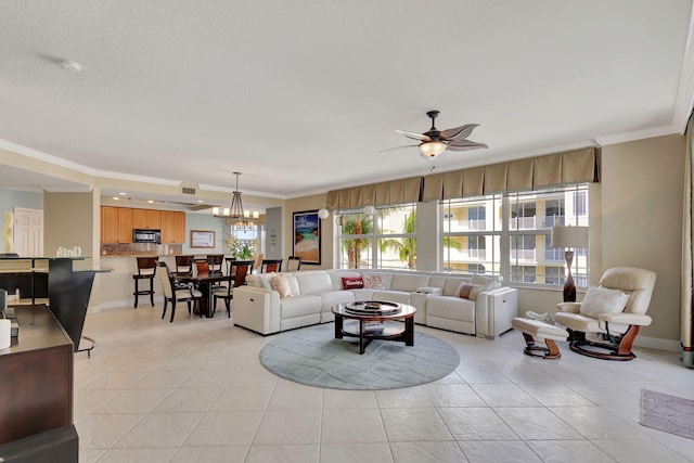 living room featuring ceiling fan with notable chandelier, light tile patterned floors, and ornamental molding