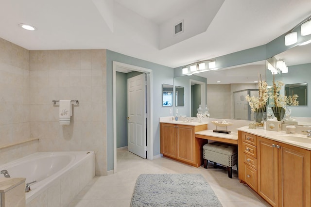 bathroom featuring tile patterned floors, vanity, and a relaxing tiled tub