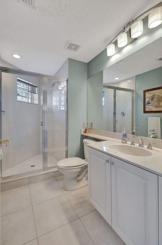 bathroom featuring tile patterned flooring, vanity, a textured ceiling, and walk in shower