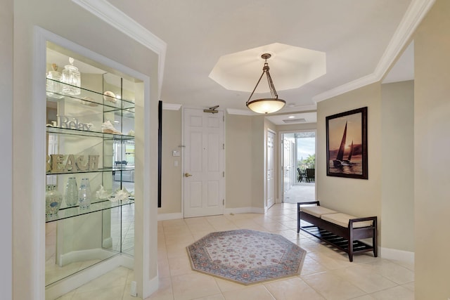 tiled foyer entrance with a raised ceiling and ornamental molding