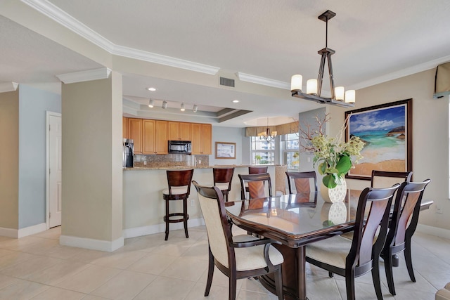 dining space featuring a tray ceiling, light tile patterned floors, ornamental molding, and a notable chandelier