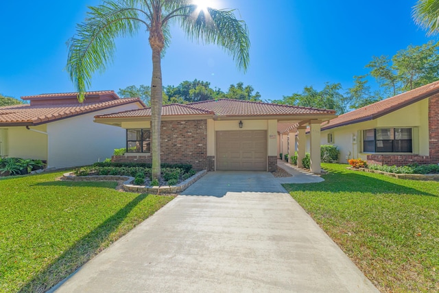 mediterranean / spanish home featuring a garage and a front lawn