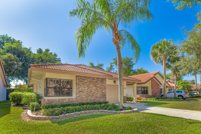 mediterranean / spanish-style home featuring a front yard and a garage