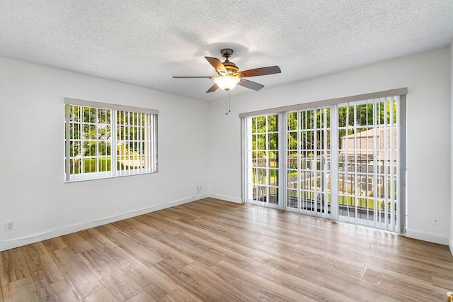1701 Vision Dr, Palm Beach Gardens, FL 33418 - unfurnished room featuring a ceiling fan, healthy amount of natural light, wood finished floors, and a textured ceiling