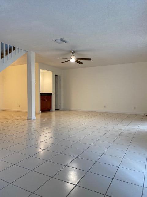 empty room featuring ceiling fan and light tile patterned floors