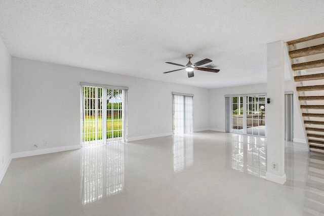 1701 Vision Dr, Palm Beach Gardens, FL 33418 - spare room featuring ceiling fan, stairs, baseboards, tile patterned flooring, and a textured ceiling