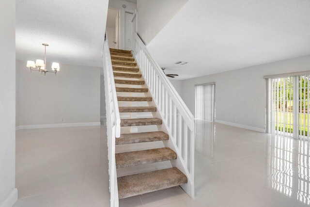 1701 Vision Dr, Palm Beach Gardens, FL 33418 - staircase featuring tile patterned flooring, a chandelier, baseboards, and a textured ceiling