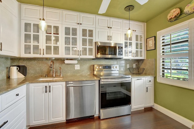 kitchen with white cabinetry, sink, stainless steel appliances, backsplash, and decorative light fixtures