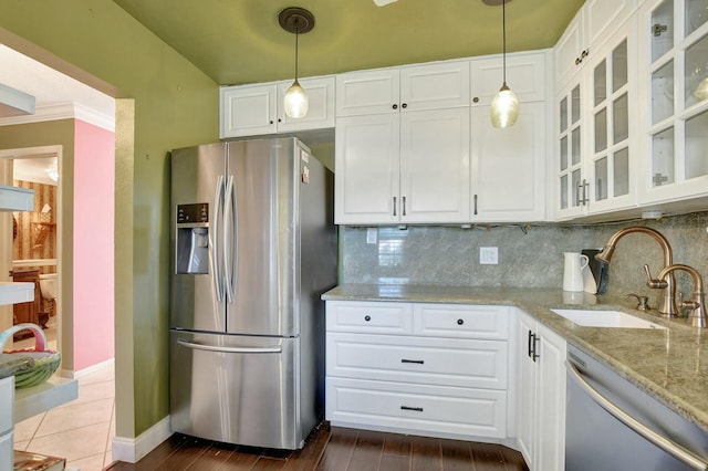 kitchen with sink, white cabinets, decorative light fixtures, and appliances with stainless steel finishes