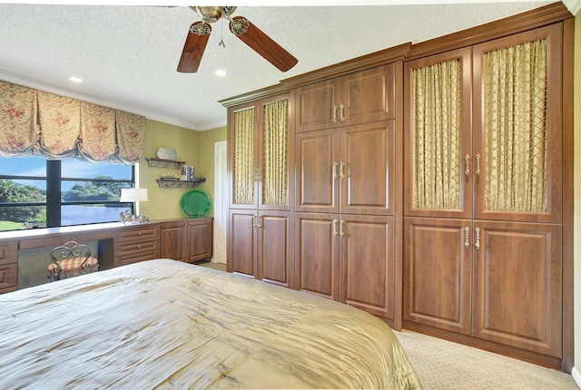 unfurnished bedroom with a water view, ceiling fan, ornamental molding, a textured ceiling, and a closet