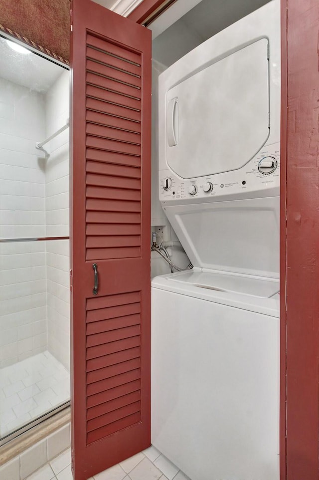 clothes washing area featuring light tile patterned floors and stacked washer / drying machine