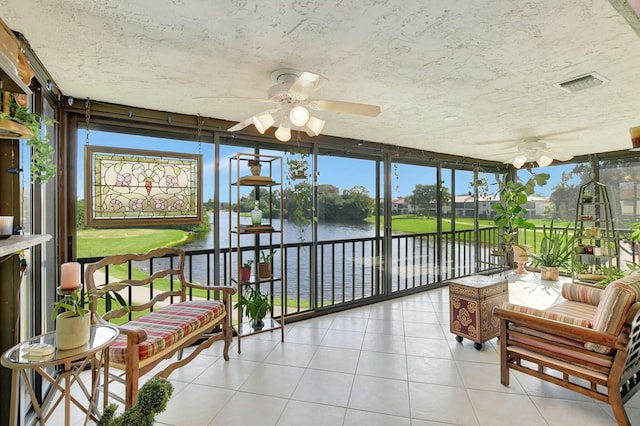 sunroom / solarium with a water view and ceiling fan