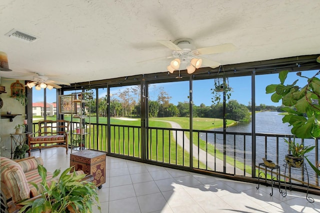 unfurnished sunroom with a water view and ceiling fan