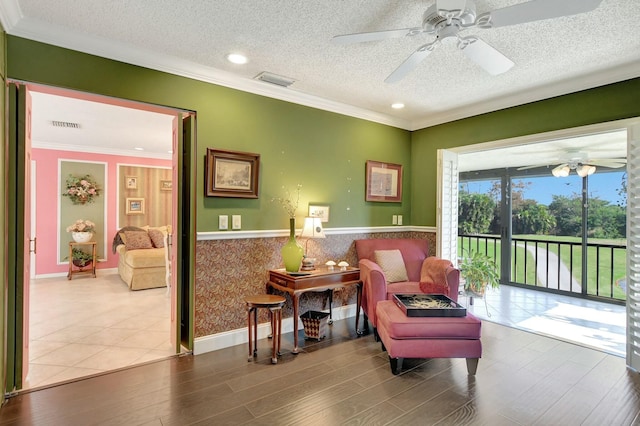 sitting room with a textured ceiling, ceiling fan, crown molding, and hardwood / wood-style flooring