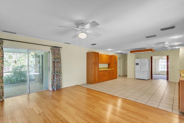 unfurnished living room featuring ceiling fan and light wood-type flooring