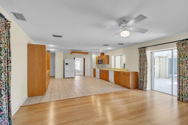 kitchen featuring ceiling fan, light wood-type flooring, white appliances, and sink