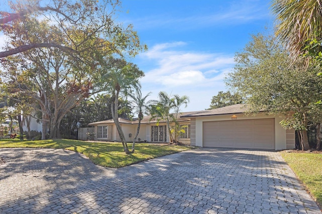 ranch-style home with a garage and a front yard