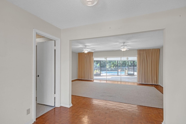 spare room featuring ceiling fan, parquet floors, and a textured ceiling